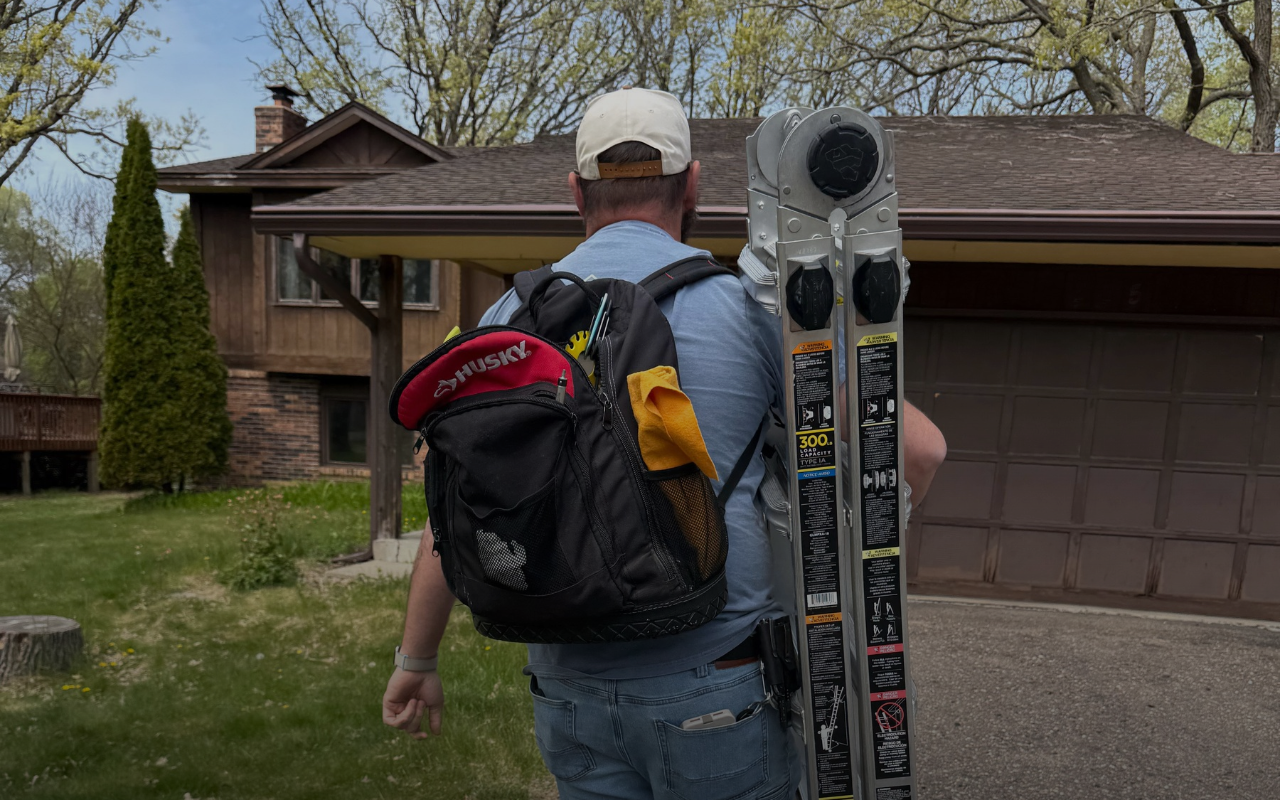 Inspector carrying a ladder into a home